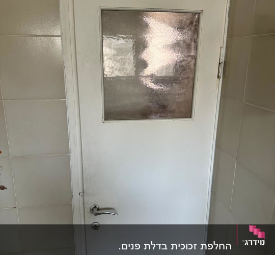 דלת עם חלון זכוכית מטושטשת בחלק העליון